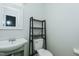 A half bath features a stylish sink with a modern rack over a white toilet at 2821 Regent Park Ln, Burlington, NC 27217