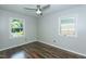 Bedroom featuring hardwood floors, ceiling fan, and natural light from two windows at 2821 Regent Park Ln, Burlington, NC 27217
