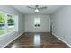An empty bedroom with wood floors, ceiling fan, and two bright windows at 2821 Regent Park Ln, Burlington, NC 27217