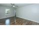 An empty bedroom with wood floors, ceiling fan, and a view to the hallway at 2821 Regent Park Ln, Burlington, NC 27217