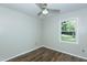 Cozy bedroom featuring a ceiling fan, wood-look floors, and a bright window view at 2821 Regent Park Ln, Burlington, NC 27217