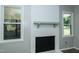 Close-up of a painted brick fireplace with white trim, and windows on either side at 2821 Regent Park Ln, Burlington, NC 27217