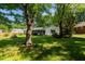 Charming single-story home with a well-maintained lawn and mature trees, offering shade and curb appeal at 2821 Regent Park Ln, Burlington, NC 27217