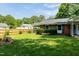 Well-maintained lawn and partial brick home exterior with black shutters offers a classic curb appeal at 2821 Regent Park Ln, Burlington, NC 27217