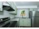 A modern kitchen with stainless steel appliances and plenty of natural light from the window at 2821 Regent Park Ln, Burlington, NC 27217