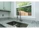 Close-up of kitchen sink, faucet, countertop, and window with view of backyard at 2821 Regent Park Ln, Burlington, NC 27217