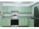 Kitchen features stainless steel appliances, light green cabinets, granite counters, and light gray walls at 2821 Regent Park Ln, Burlington, NC 27217