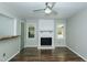 Bright living room with wood floors, a ceiling fan, and a painted brick fireplace at 2821 Regent Park Ln, Burlington, NC 27217