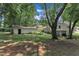 Large backyard with mature trees, lush landscaping, green lawn, and a detached garage at 3509 Crofton Ct, Raleigh, NC 27604