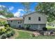 View of the home's rear exterior, patio, outdoor seating, and lush landscaping with a green lawn at 3509 Crofton Ct, Raleigh, NC 27604