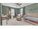 Bedroom with crib, chair, ceiling fan, and neutral carpet at 3509 Crofton Ct, Raleigh, NC 27604