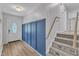 Inviting entryway featuring wood-look floors, stairs, stylish blue paneling, and a decorative glass front door at 3509 Crofton Ct, Raleigh, NC 27604