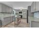 Modern kitchen featuring stainless steel appliances, gray cabinets, granite countertops, and stylish backsplash at 3509 Crofton Ct, Raleigh, NC 27604