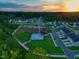 Aerial view of a vibrant community with a pool, playground, and green spaces at sunset at 380 Chesapeake Commons St # 129, Garner, NC 27529