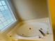 Inviting garden tub with jets for ultimate relaxation underneath a frosted window at 417 Downing Glen Dr, Morrisville, NC 27560