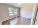 Sunlit bedroom featuring a large window and light-colored walls, complemented by pristine hardwood floors at 417 Downing Glen Dr, Morrisville, NC 27560