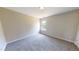 Bedroom with neutral-colored walls and carpet, featuring a window that fills the room with natural light at 417 Downing Glen Dr, Morrisville, NC 27560