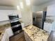 Renovated kitchen with granite counters, stainless appliances, and a functional island at 417 Downing Glen Dr, Morrisville, NC 27560