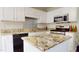 Modern kitchen featuring granite countertops, stainless steel appliances, and white cabinetry at 417 Downing Glen Dr, Morrisville, NC 27560