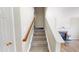 Carpeted staircase with wood railing, leading to a cozy living area with fireplace and hardwood floors at 417 Downing Glen Dr, Morrisville, NC 27560