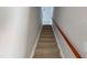 Carpeted stairway with wooden handrail leading upstairs, providing a safe and stylish transition between levels at 417 Downing Glen Dr, Morrisville, NC 27560