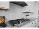 Close up of stove top with granite counters and white backsplash at 4508 Valley Crest Ln, Fuquay Varina, NC 27526