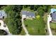 An overhead view shows a landscaped property with mature trees, a large lawn, and a beautiful home at 4601 Basilica Dr, Holly Springs, NC 27540