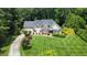 An aerial shot shows a beautiful landscaped lawn, mature trees, and a traditional home design with a long private driveway at 4601 Basilica Dr, Holly Springs, NC 27540