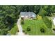 Aerial view of a well-manicured property with a long driveway, beautiful landscaping, and mature trees surrounding the home at 4601 Basilica Dr, Holly Springs, NC 27540