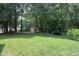 Beautiful backyard featuring a storage shed, manicured lawn, and mature trees, perfect for outdoor activities and relaxation at 4601 Basilica Dr, Holly Springs, NC 27540