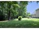 A spacious backyard boasts lush green grass, mature trees, and a patio area, perfect for outdoor entertaining at 4601 Basilica Dr, Holly Springs, NC 27540