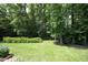 A beautiful backyard featuring a well-maintained lawn, mature trees and manicured hedges create a private oasis at 4601 Basilica Dr, Holly Springs, NC 27540