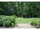 Landscaped backyard featuring a lush lawn, mature trees, and garden beds for outdoor enjoyment at 4601 Basilica Dr, Holly Springs, NC 27540