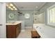 Bathroom featuring a soaking tub, glass-enclosed shower, and light tile flooring at 4601 Basilica Dr, Holly Springs, NC 27540