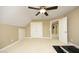 Spacious bonus room with neutral carpeting, a ceiling fan, and multiple access doors at 4601 Basilica Dr, Holly Springs, NC 27540