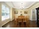 Bright dining room with wood floors, natural light, and classic chandelier for elegant meals at 4601 Basilica Dr, Holly Springs, NC 27540