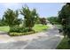 A long driveway leads to a home, framed by landscaped garden beds and mature trees, offering a picturesque arrival at 4601 Basilica Dr, Holly Springs, NC 27540