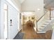 Inviting home foyer with wood floors, staircase, and view into the dining room; bright and spacious at 4601 Basilica Dr, Holly Springs, NC 27540