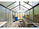 Interior of a greenhouse, featuring plant racks, storage containers, and natural light at 4601 Basilica Dr, Holly Springs, NC 27540