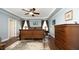 Main bedroom with a tray ceiling, dark wood furniture, and neutral color scheme at 4601 Basilica Dr, Holly Springs, NC 27540