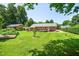 Spacious backyard with lush green lawn and mature trees and shrubbery at 5 Windsor Pl, Mebane, NC 27302
