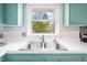 Bright kitchen view with a stainless sink, a window that looks out to the backyard, and painted cabinets at 5 Windsor Pl, Mebane, NC 27302