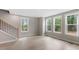 Open living room boasts hardwood floors, three bright windows, and staircase to second story at 509 Sherron Road Dr # 10, Durham, NC 27703