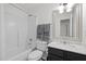 Bright bathroom featuring a shower-tub combo, black vanity with stone countertop and decorative mirror at 5332 Seaspray Ln, Raleigh, NC 27610