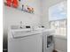 Bright laundry room featuring modern washer and dryer with storage shelf and natural light from window at 5332 Seaspray Ln, Raleigh, NC 27610