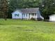 A well-maintained front yard leads up to this charming blue house with white trim and blue shutters at 535 Hillcrest Dr, Garner, NC 27529