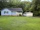 A cozy single-Gathering home with a detached garage is nestled in a green, wooded landscape at 535 Hillcrest Dr, Garner, NC 27529