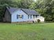 A blue house with blue shutters and a detached garage is set back from the street at 535 Hillcrest Dr, Garner, NC 27529