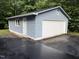 A detached one-car garage with white door and blue siding offers ample parking and storage at 535 Hillcrest Dr, Garner, NC 27529