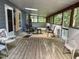 A screened porch with wooden flooring and several chairs invites relaxed outdoor enjoyment at 535 Hillcrest Dr, Garner, NC 27529